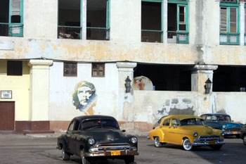Che Guevara image on wall behind vintage American cars