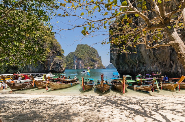 boats on Thai shore depict how island hopping in Thailand can mend a broken heart