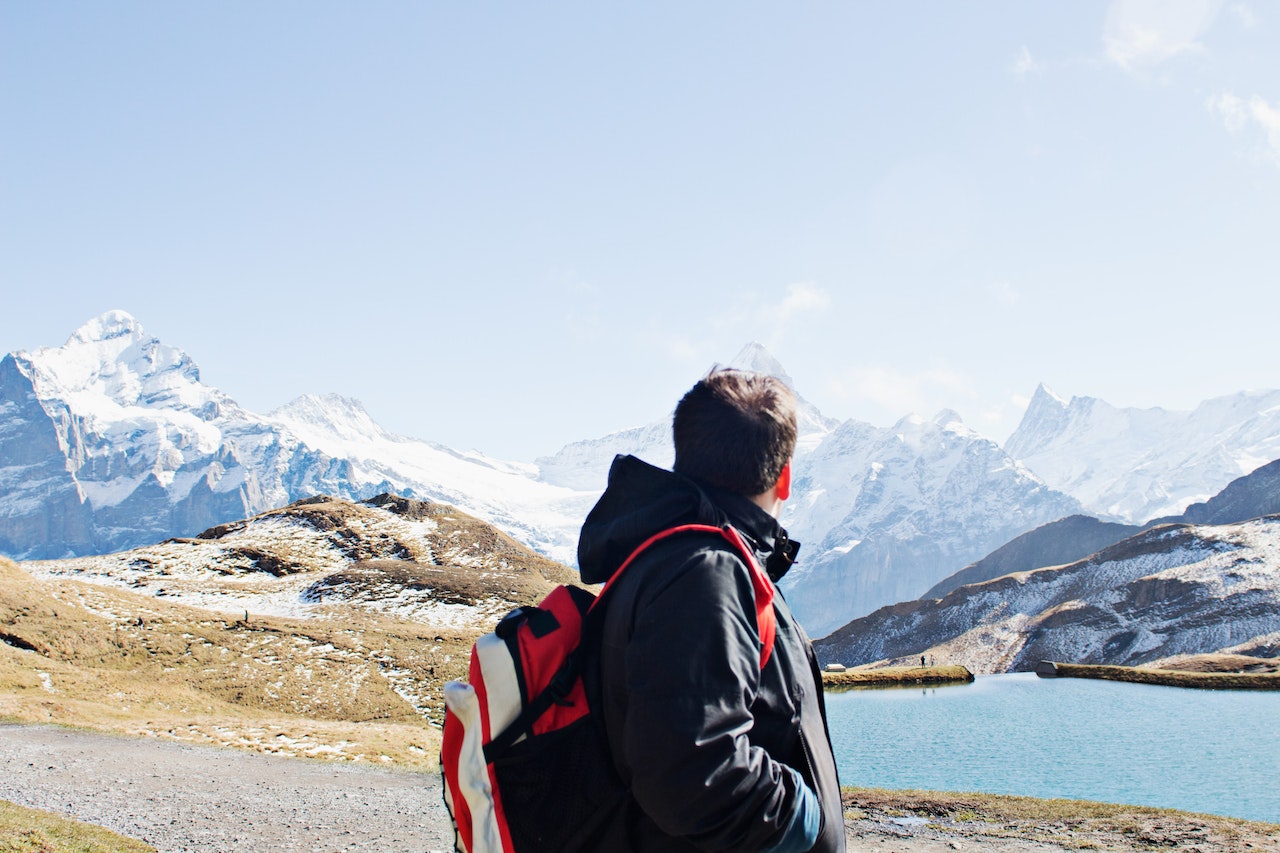 a man with a backpack enjoying the beauty of Switzerland through hiking