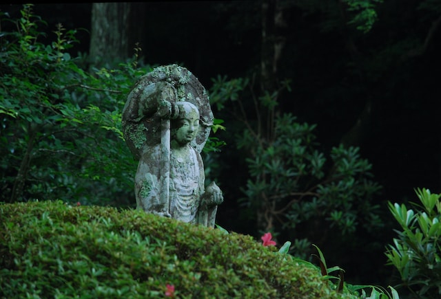 Statue hidden in vegetation.