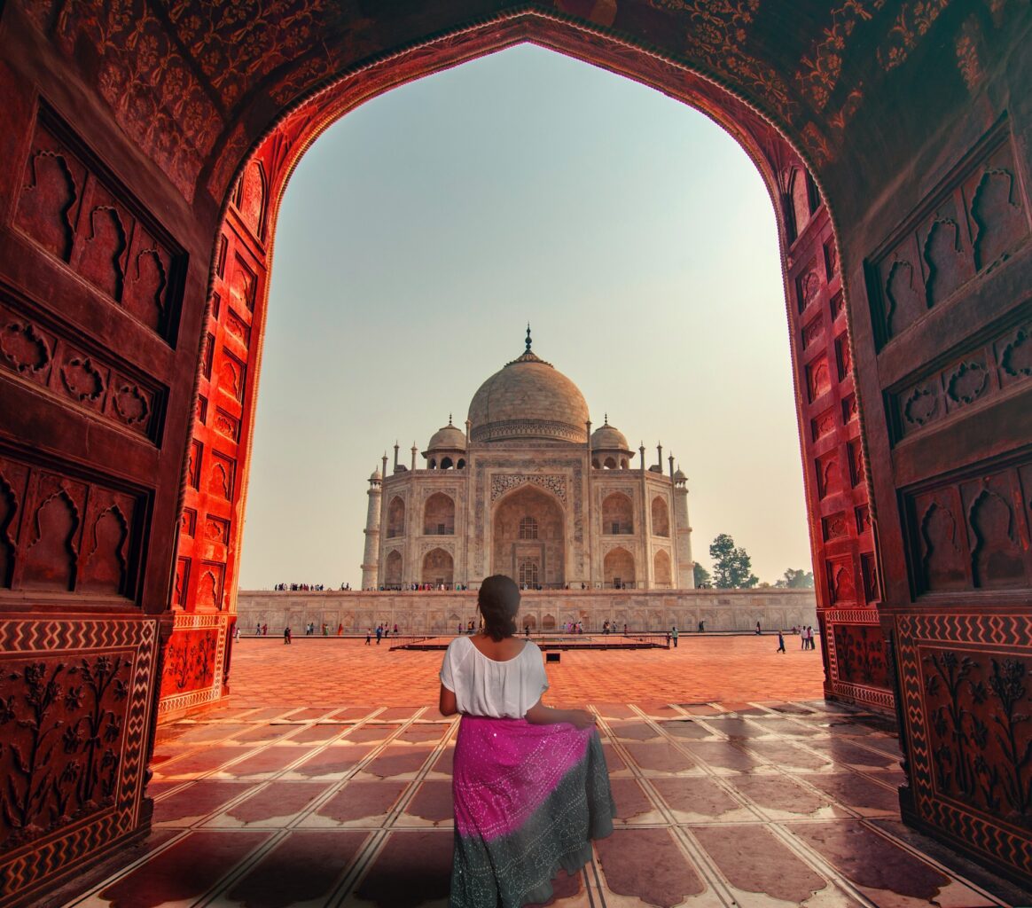 A girl standing in front of the Taj Mahal