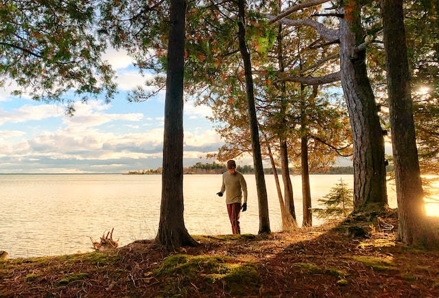 A man hiking alongside a lake.