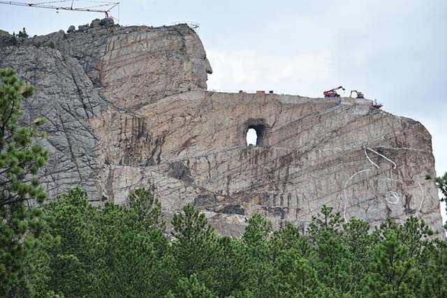 Workers atop Mount Rushmore with cranes