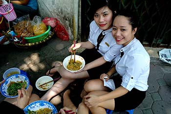 women eating lunch on street