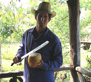 farmer opening coconut with machete
