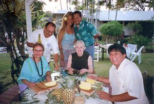the author and friends cutting a pineapple on Maui