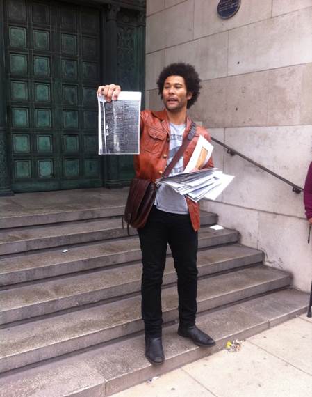 Laurence holding newspaper