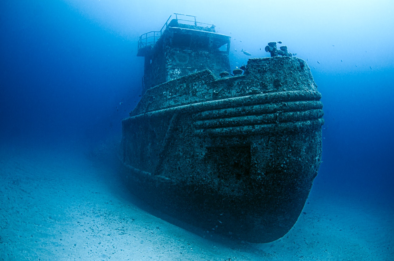 A big, old, sunken ship at the bottom of the sea.