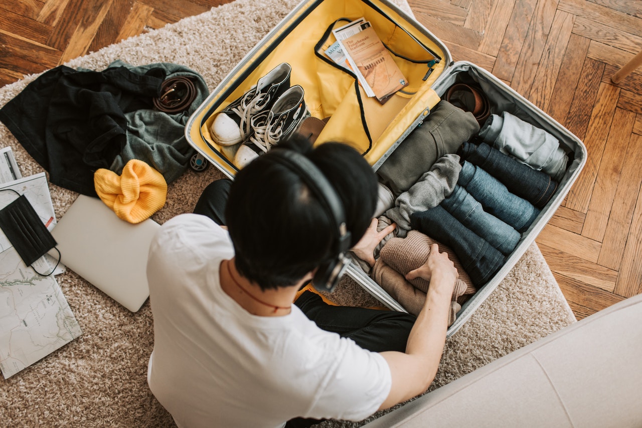 A man listening to music and packing for a trip that will allow him to explore offbeat things to do in Goa.