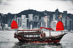 black and red boat with skyscrapers in the background
