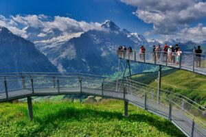 people on the First Cliff Walk by Tissot with mountains in front of them