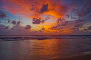 A beach at sunset with cloudy skies