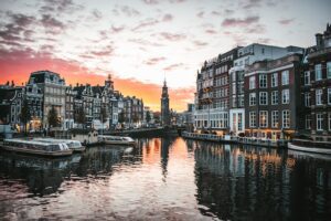 City's scenery at sunset with architecture, river, and boats