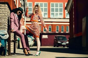 2 fashionable women posing in front of a building