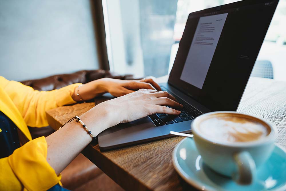 woman uses laptop computer at coffee shop