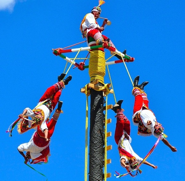 men hanging from pole