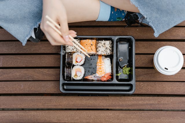 A person enjoying sushi with chopsticks, highlighting the diverse flavors of Vancouver’s culinary scene.