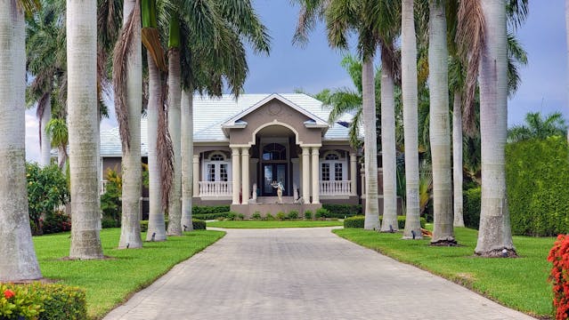 A grand house surrounded by palm trees, reflecting Florida's serene residential living near Florida's antebellum estates and historic plantations