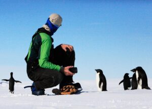 man and penguins in Antarctica