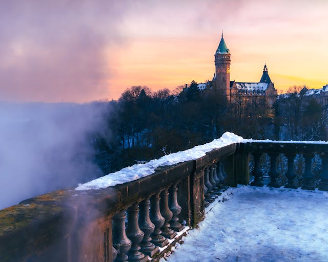 stone balcony with snow overlooking a castle in Luxembourg