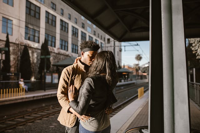 A couple shares a warm embrace on a quiet train platform, adding a human moment to the historic charm of LA’s forgotten train stations